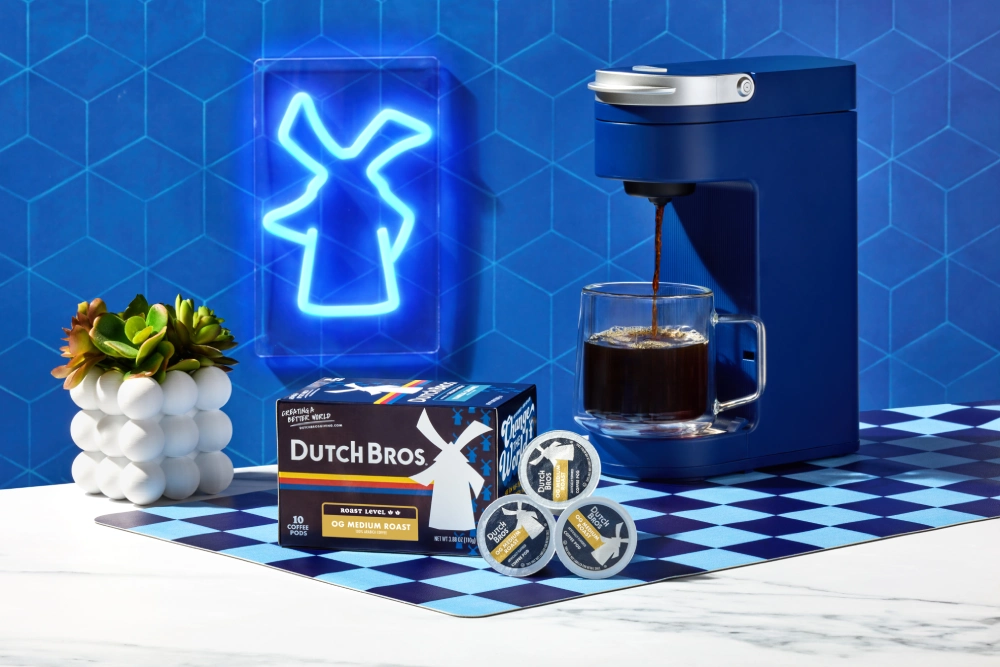 Dutch bros logo illuminated with coffee machine brewing coffee
