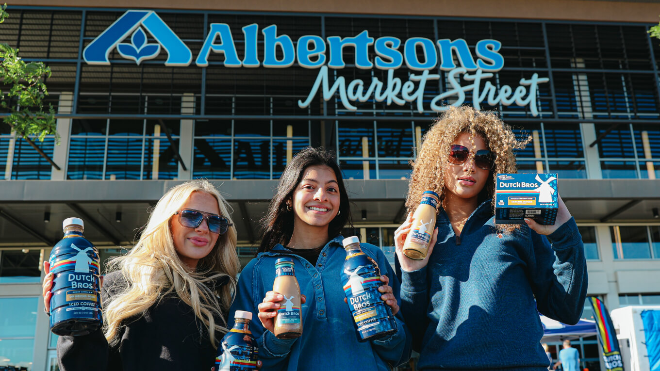 3 women holding DutchBros products at event