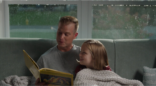 Dad reading book to daughter