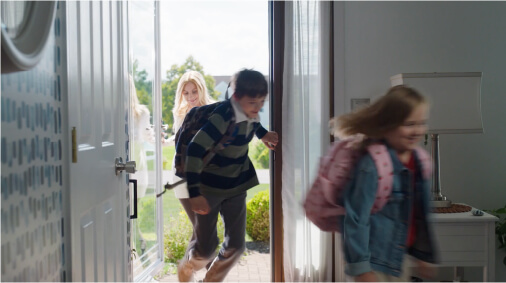 Mom walking in house with two small children afterschool