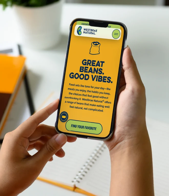 Great beans. Good vibes. Person viewing Westbrae website on mobile device.